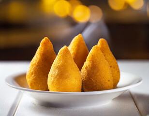 Five coxinhas fried chicken snack typical of
Brazil stylized on white dishes