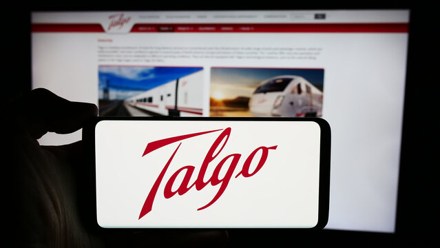 Stuttgart, Germany - 04-08-2024: Person holding cellphone with logo of Spanish train manufacturing company Talgo S.A. in front of business webpage. Focus on phone display.
