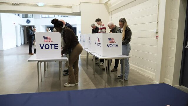 4K: Group of Voters voting at Polling Place for the USA Presidential Election.  People Vote at booths. Tracking shot. Stock Video Clip Footage