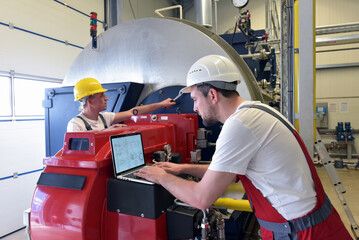Mechanics repair a machine in a modern industrial plant - profession and teamwork - 785408182