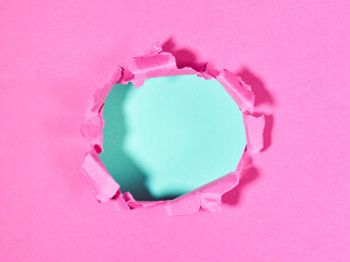 Ripped pink paper with hole in the center