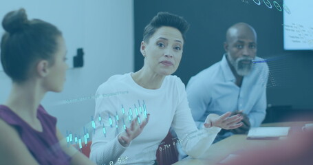 Image of financial data and graphs over diverse businesswoman explaining to coworker in meeting