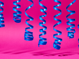 decorative blue streamer ribbon on pink background