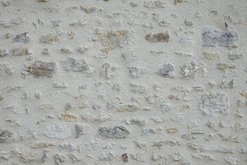 Mur extérieur de pierres en. enduit beige