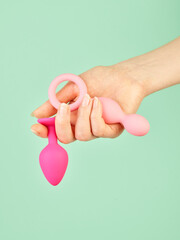 Woman's hand holding adult sex toy over mint background - 785414731