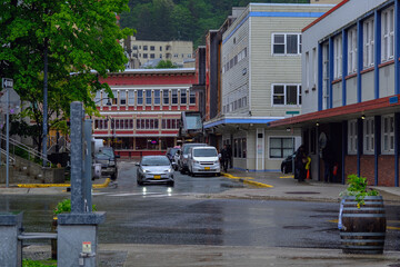 Grey, misty, foggy morning in Juneau Bay, Alaska with small islands channel cruising and houses, glacier mountains and low clouds downtown historic old town shopping district streets