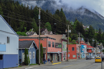Historic old wooden houses facades along Creek in downtown Ketchikan, Alaska with colorful buildings, fisherman homes, marina with boats and tourist traffic on road popular cruise ship destination