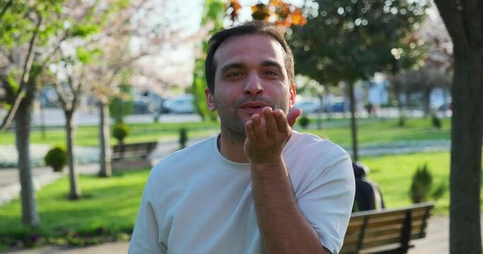 A man looks at the camera and makes gestures and facial expressions that resemble the phrase "call me"