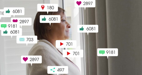 Image of changing numbers, icons in notification bars, senior thoughtful biracial woman