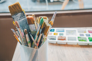 Close-up of several brushes used for painting placed on a table.