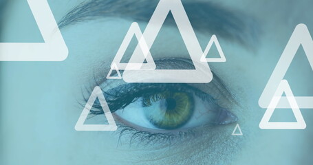 Image of white triangles flying up over woman's eye