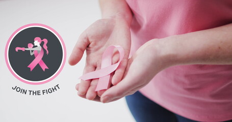 Join the fight text banner with female boxer icon against mid section of woman holding a pink ribbon - Powered by Adobe