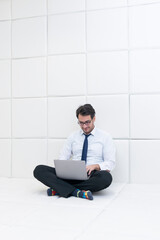 Sad and frustrated businessman in formal wear sitting in a white room in a mental hospital	