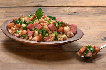 Feijão tropeiro in a wooden container, typical food from Minas Gerais, Brazil, wooden base 
