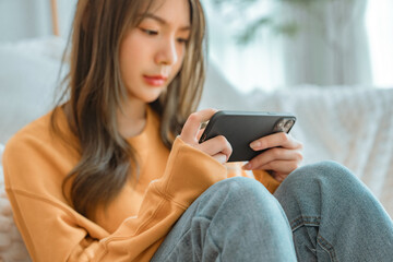Closeup - Worried young woman looking at smartphone screen, dissatisfied with bad news message, spam or scam sms. Bad mood lifestyle concept.