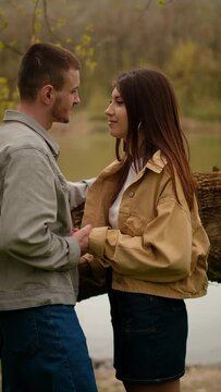 Young love and friendship: a teenage couple embraces by the lake, expressing first feelings and a kiss. Capturing the essence of a first date and romantic meeting spots, alongside teen clothing brands