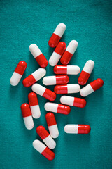 Red and white pills on a green fabric - 785440533