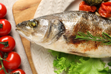 Delicious baked fish and vegetables on table, top view