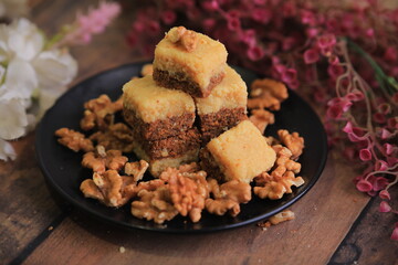 Famous Indian sweet Kalakand Made Of Khoya Doodh Malai Decorated With Badam Or Badaam garnished with Nuts Kaju And Pista closeup with selective focus and blur