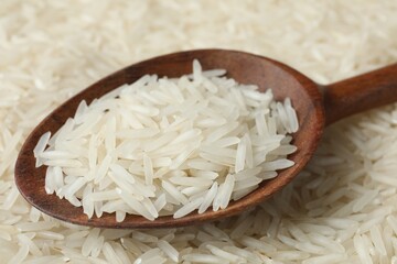 Raw basmati rice and spoon as background, closeup