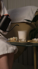 couple relaxing and drinking tea in the spa lounge. Pouring hot water into plastic cup. Couple drinking tea in spa salon
