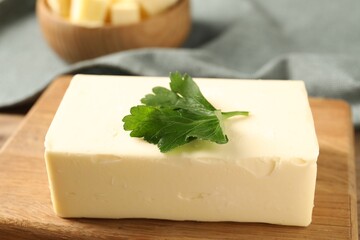 Tasty butter with parsley on wooden table, closeup