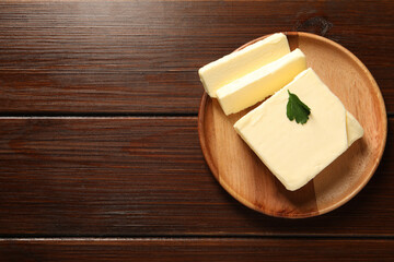 Cut tasty butter on wooden table, top view. Space for text