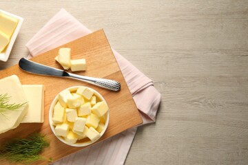 Tasty butter with dill and knife on wooden table, flat lay. Space for text