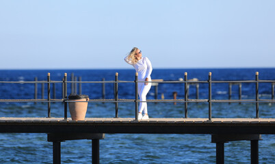 girl in a white tracksuit on the pier