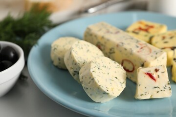 Tasty butter with herbs and spices on white table, closeup