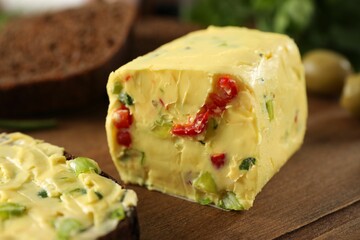 Tasty butter with green onion and chili pepper on wooden board, closeup