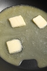 Melting butter in frying pan, closeup view