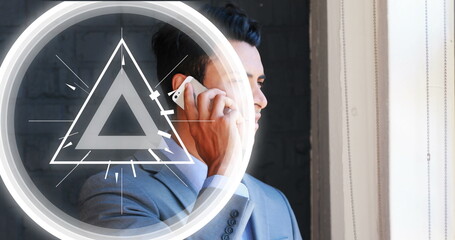 Image of abstract triangular shape pulsating over biracial businessman talking on smartphone