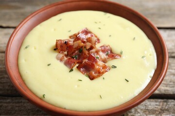 Tasty potato soup with bacon in bowl on table, closeup