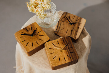 Walnut wall clock. Dry flowers in a vase on the table.