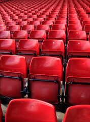 Close-up of the empty red seats in football stadium. Sport background pattern photo.