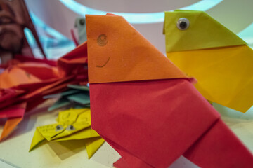 Close-up of paper folding in bird shape. Kids' diy, art craft. Creative work.