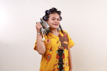 Happy asian housekeeper woman standing while making phone gesture with an iron