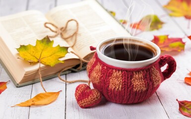 Knitted cup of coffee, book, heart and autumn leaves