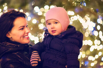 Mother and little daughter over Christmas background