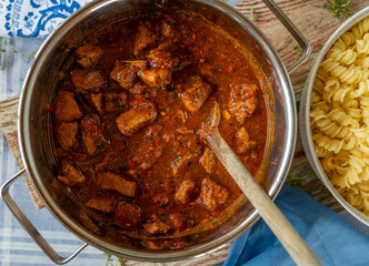 Pork goulash hungarian style with paprika, onions, tomatoes. Served ready to eat in a cooking pot