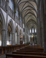 Fototapeta premium Avranches, France - Apr 13, 2024: Notre-Dame-des-Champs Cathedral. People walking in Avranches. Streets and buildings. Lifestyle in the urban area. Sunny spring day. Selective focus