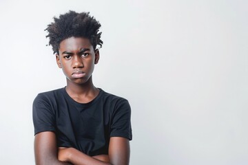Fototapeta na wymiar Photo of a stubborn black teenage boy on white background. Concept of adolescence, transition period, puberty, hormonal changes, psychological problems of children, teenagers, young generation.