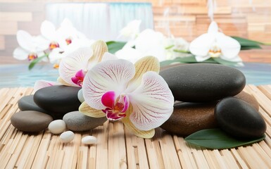 Spa stones, orchid flower heads on a wooden background