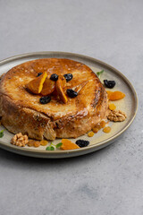cake with dried apricots, raisins and walnuts on grey background