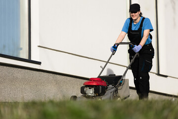 Woman mowing the lawn with a petrol mower