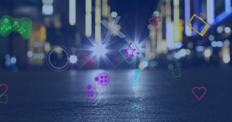 Image of multiple image game icons floating against city traffic at night
