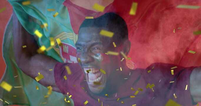 Image of gold confetti over cheering african american male sports fan waving flag of portugal - Powered by Adobe