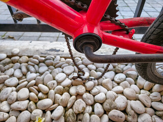 Broken rusty bicycle chain with red frame