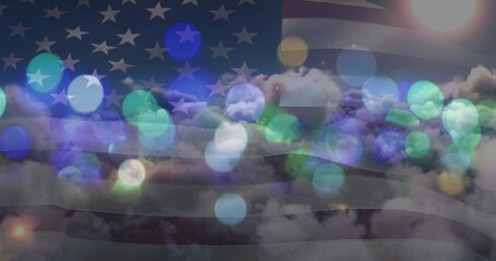 Image of glowing spots over sky with clouds and american flag